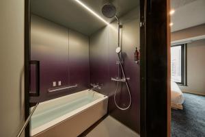 东京The Royal Park Canvas Ginza Corridor的设有带浴缸和淋浴的浴室。