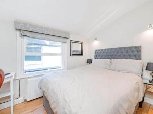 伦敦4 Bedroom Residence Hammersmith Fulham的白色的卧室设有一张大床和一个窗户