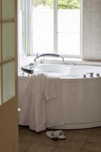 锡姆里斯港哈塞贝肯别墅酒店的浴室内设有带毛巾的浴缸