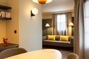 格勒诺布尔RockyPop Grenoble Appartements的带沙发和黄色枕头的客厅
