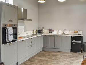 EccleshallSheepfold Cottage的厨房配有白色橱柜和不锈钢用具
