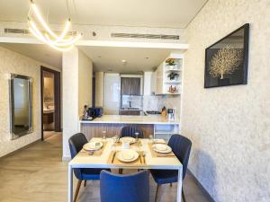 迪拜STAY BY LATINEM Luxury 1BR Holiday Home OPA 802 near Burj Khalifa的一间配备有白色桌子和蓝色椅子的用餐室