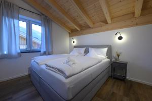 加尔米施-帕滕基兴Alpjuwel的窗户客房内的一张大白色床