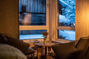 尤卡斯耶尔维冰之酒店的一间带椅子和桌子的房间以及两个窗户