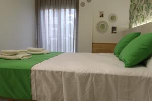 洛斯马蒂雷斯203 I Posada del Mar I Encantador hostel en la playa de Gandia的一张绿色和白色的床,配有绿色枕头