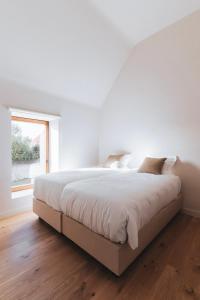 奥德纳尔德Vakantiewoning Duisbeke Logies的白色的卧室设有一张大床和一个窗户