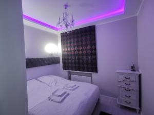 比亚韦斯托克WM Centrum Glamour z parkingiem的一间卧室配有一张粉红色照明床