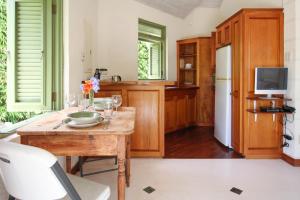 圣詹姆斯Marsh Mellow South Cottage by BSL Rentals的厨房配有木桌和白色冰箱。