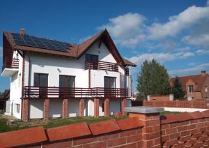 PrejmerVila Sol的屋顶上设有太阳能电池板的房子