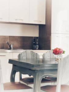 拉莫赫莱Stableyard cottages的厨房里摆放着白色橱柜和鲜花的桌子