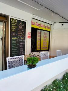 清迈Baan Chiang Maan的一间有白色柜台和墙上标志的餐厅