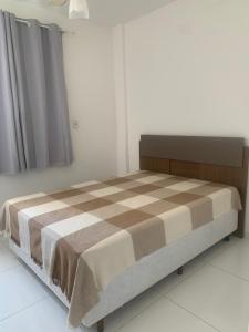 瓜拉派瑞Apto 2 Quartos Perfeito的一间卧室配有一张床,床上有条毯子