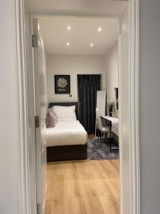 伦敦Elegant 2 Bed Flat in Chiswick的一间卧室配有一张床、一张桌子和一张书桌