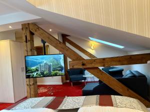 梅尔齐希Hotel Stadtvilla Laux的一间卧室设有一张高架床和一台平面电视。