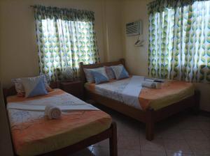 长滩岛Ocean Breeze Inn的一间卧室设有两张床和两个窗户。