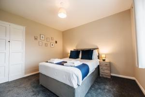 蒂斯河畔斯托克顿Wolviston House By Horizon Stays的一间卧室配有一张带蓝色枕头的大床