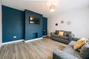 蒂斯河畔斯托克顿Wolviston House By Horizon Stays的客厅设有两张沙发和一堵蓝色的墙壁