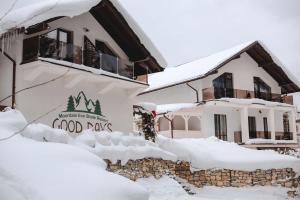 亚布卢尼齐亚GOOD DAYS Shale Resort 4 км до Буковеля的雪覆盖着的房屋,上面标有读食日