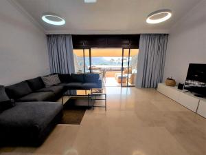 大加那利岛拉斯帕尔马斯Villa Happiness - Luxury chalet with sea view的客厅配有黑色沙发和电视