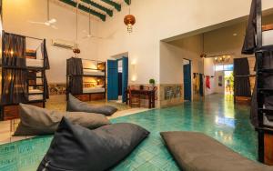 梅里达Che Nomadas Mérida Hostel Adults Only的客房在地板上设有带枕头的游泳池