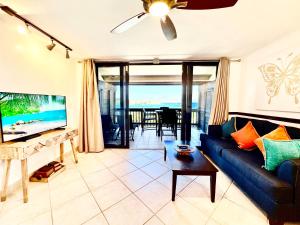 East EndSapphire Beachfront Renovated Villa 1200 SF! - Free Wi-Fi的客厅配有蓝色的沙发和桌子