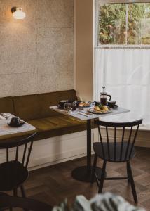 巴斯Leighton House - Boutique Guesthouse的一张桌子,上面有盘子,放在沙发旁