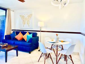 East EndSapphire Beachfront Renovated Villa 1200 SF! - Free Wi-Fi的客厅配有蓝色的沙发和桌子