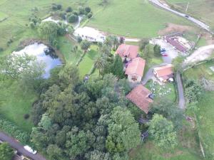 VillanuevaCasona Dos Lagos的享有树木和池塘的房屋的空中景致