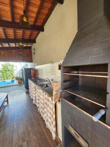 圣若昂-巴蒂斯塔-杜格罗里亚Pousada Luz de Candeia的厨房配有大型烧烤架和水槽