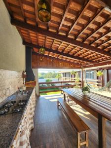 圣若昂-巴蒂斯塔-杜格罗里亚Pousada Luz de Candeia的厨房设有木制天花板和长凳桌子。