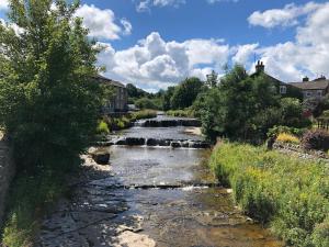 HawesQuarry Cottage near Hawes, Yorkshire Dales, Pet free的一座有瀑布的小镇上一条河流