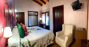 科瓦鲁维亚斯多纳沙茶酒店的一间卧室配有一张床、一把椅子和电视