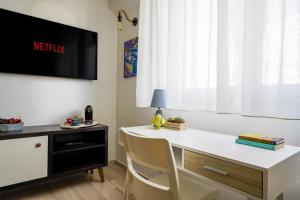 巴里Mediterranea Apartment- CENTRAL STATION - FREE WIFI&NETFLIX的客房设有白色的办公桌和墙上的电视。