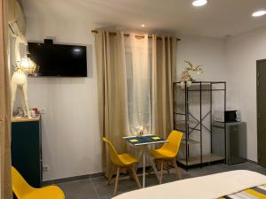纳博讷LA DI MARIA的配有桌椅和电视的客房