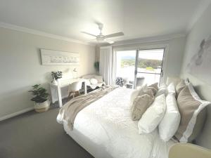 科夫斯港Diggers Beach Villa Coffs Harbour的卧室配有一张大白色床和窗户