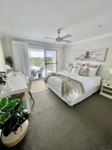 科夫斯港Diggers Beach Villa Coffs Harbour的白色的卧室设有一张大床和一个窗户