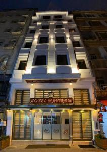 伊斯坦布尔Hotel Mavirem的前面有商店的白色建筑