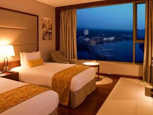 科钦科钦皇冠假日酒店的酒店客房设有两张床和大窗户。