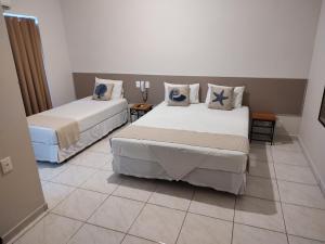 圣塞巴斯蒂安Hotel Guarda Mor的客房设有两张床,铺有瓷砖地板。