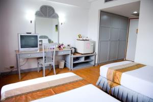 董里图姆林酒店的一间卧室配有两张床和一张书桌及电视