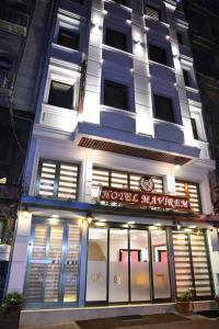 伊斯坦布尔Hotel Mavirem的夜间在建筑物前的商店