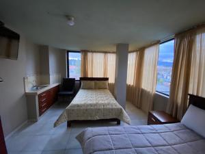 昆卡Hostal el Paraíso的一间卧室设有两张床和一个水槽,窗户