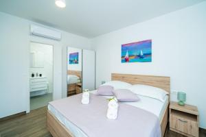 杜布罗夫尼克Blue Bay Apartment的一间卧室配有一张带白色床单和紫色枕头的床