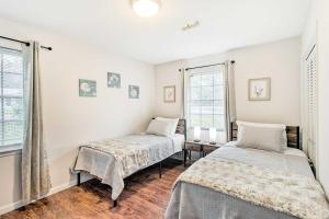 海恩斯维尔Bright Hinesville Home, 43 Mi to Savannah!的一间卧室设有两张床和两个窗户。