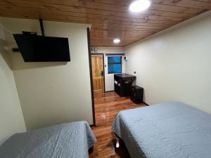 Santa BárbaraHospedaje Santa Barbara的一间卧室配有两张床和一台平面电视