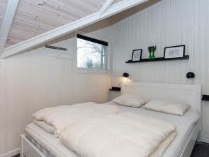海默特Holiday home Hemmet XV的窗户客房内的一张白色床