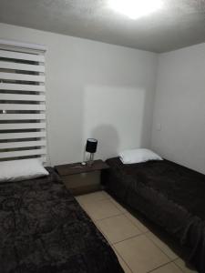 瓜达拉哈拉Excelente Departamento céntrico.的一间卧室设有两张床和窗户。