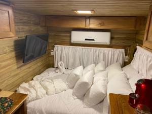 卡内拉Chale Sobre Rodas e Spa Exclusive - Localizado Próximo do Centro的客房内的一张带白色枕头的床