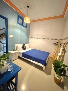 会安Hi Hợp Yến Homestay的一间卧室配有蓝色的床和蓝色的桌子