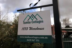 Tumbarumba1885 Warehouse Apartment的悬挂在柱子上的标志